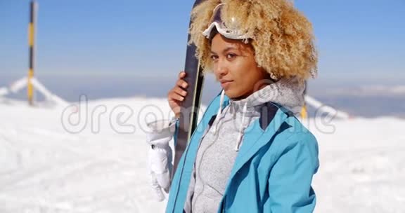 体贴的年轻女子站着拿着她的滑雪板视频的预览图