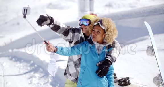 有趣的年轻夫妇在雪地里摆姿势自拍视频的预览图