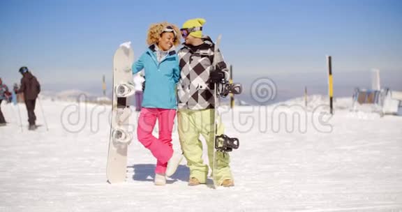 快乐的年轻夫妇摆着他们的雪板视频的预览图