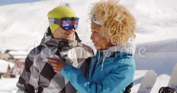 一位成年女性在滑雪板附近看朋友视频的预览图