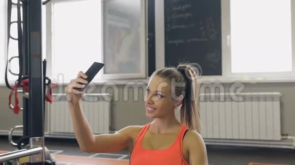 运动女性在健身房拍照自拍照年轻女孩在健身中心拍照视频的预览图
