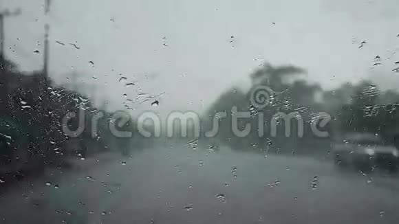 雨滴在我的汽车前面的玻璃上雨刷在路上工作视频的预览图
