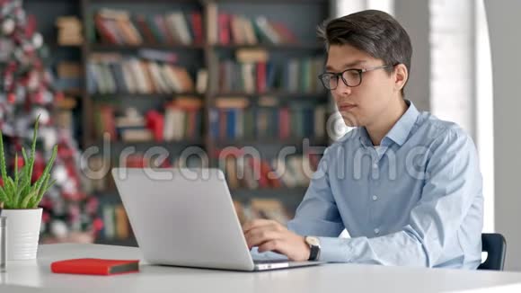 学生在学校图书馆准备考试和学习课程研究笔记本电脑和上网视频的预览图