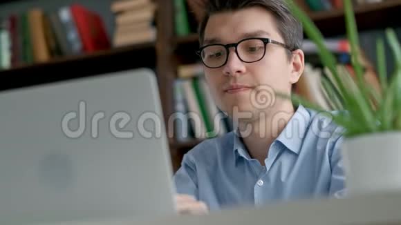 男大学生在做家庭作业时若有所思地看着笔记本电脑屏幕特写镜头集中的男孩视频的预览图