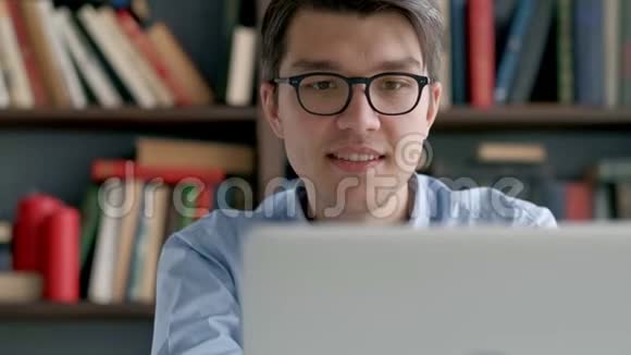 男大学生在做家庭作业时若有所思地看着笔记本电脑屏幕特写镜头集中的男孩视频的预览图
