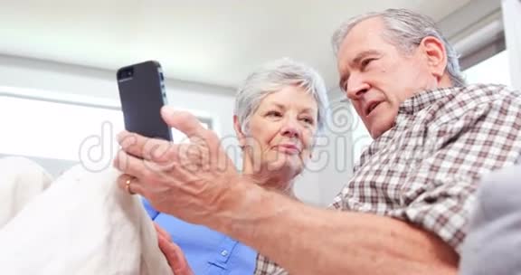 可爱的老年夫妇使用智能手机视频的预览图