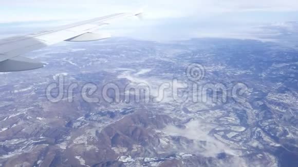 从飞机上可以看到空中景色在冬季的雾霭中飞越山脉意大利的风景视频的预览图