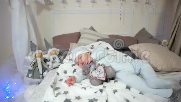甜美的梦中可爱的男孩孩子抱着玩具睡觉小孩子睡觉婴儿躺在床上的滑块和视频的预览图