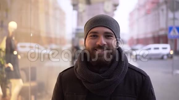 城市冬天一个快乐的年轻人在街上的画像视频的预览图