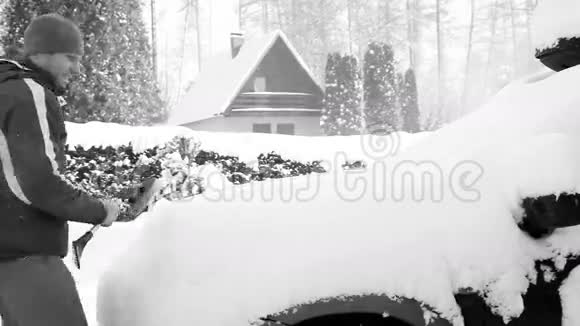 黑白镜头暴风雪过后的人清洁汽车视频的预览图