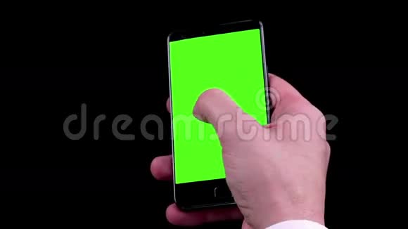 男人用智能手机写带有色度键的短信黑色背景的绿色屏幕视频的预览图