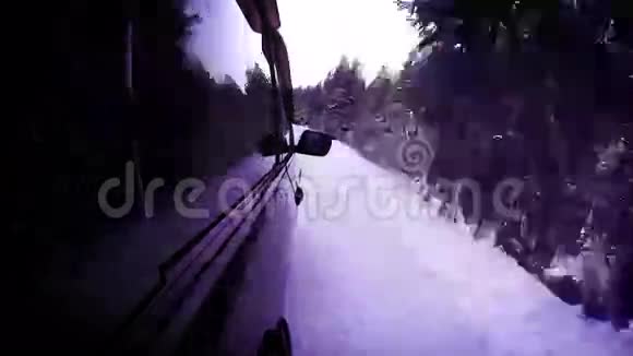 4K冬季假日录像在去滑雪场的路上汽车正在雪林中巡航视频的预览图