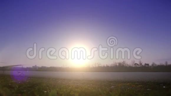 日落时两名骑自行车的人朝一个方向骑着的明亮的饱和镜头视频的预览图