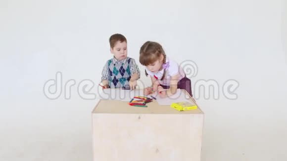小女孩和男孩用蜡笔画画视频的预览图