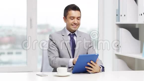 带着平板电脑和咖啡杯的微笑商人视频的预览图