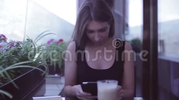 坐在咖啡馆里用笔记本电脑的年轻美女视频的预览图