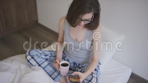 有咖啡浏览智能手机的女人视频的预览图