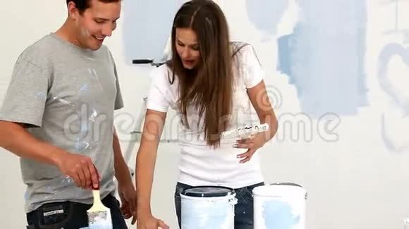 快乐的一对夫妇搅拌油漆视频的预览图