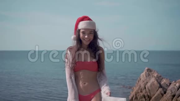在游泳池附近的年轻女子戴着圣诞帽庆祝新年和圣诞节视频的预览图