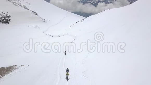 在冬季旅行中一群游客攀登雪山峰视频的预览图