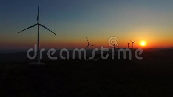 夕阳落在山上优雅的风车后面视频的预览图