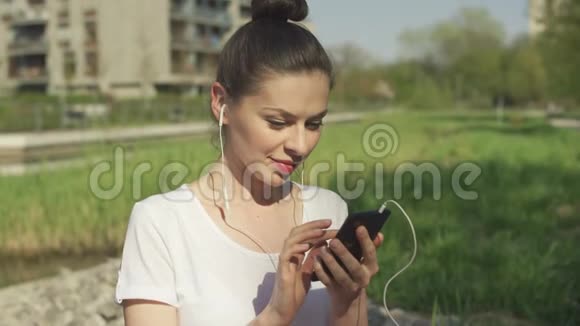 年轻的黑发戴着智能手机的耳机视频的预览图