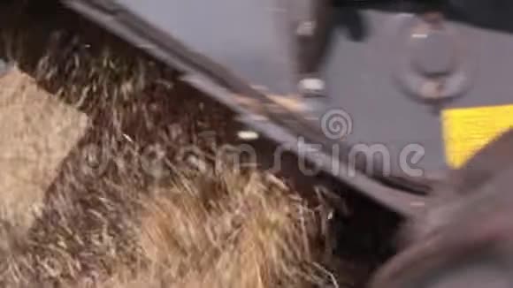 联合收割机正在运行割下来的稻草从联合收割机下面飞出来后景视频的预览图