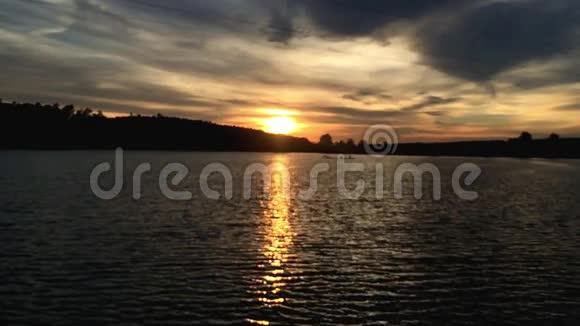 美丽的日落和湖中的水倒影阳光下的独木舟视频的预览图