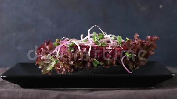 自制纯素黑汉堡与甜菜根切片芽香菜和绿色沙拉在黑色盘子在黑暗视频的预览图