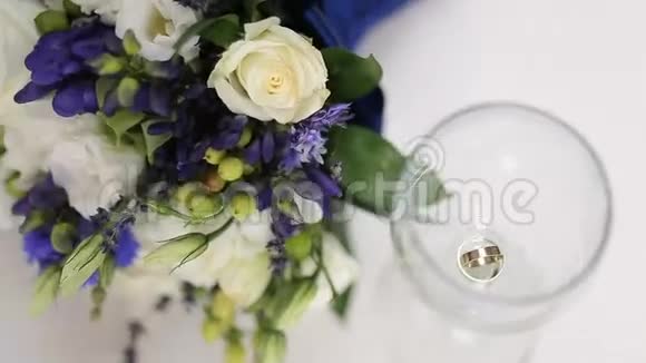 漂亮的新娘花束和结婚戒指在一杯酒视频的预览图
