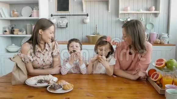 为一个幸福的家庭提供早餐姐妹双胞胎妈妈带着两个孩子女孩和男孩早上吃甜点和水果视频的预览图