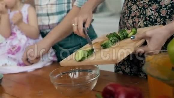 母亲和孩子在厨房里玩蔬菜在厨房里准备午餐视频的预览图
