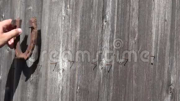 乡下人的手把生锈的旧马蹄挂在古老的木门上象征着幸运4K视频的预览图