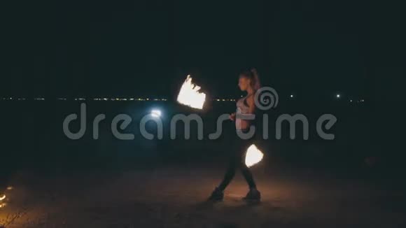 一个迷人的金发女人晚上在火上表演视频的预览图