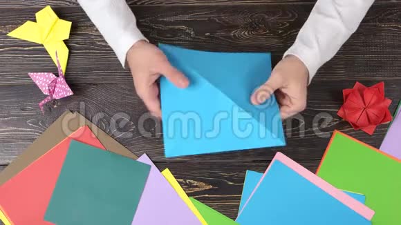 人从蓝纸上折叠折纸图形视频的预览图