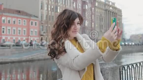 迷人的年轻女子在河边的古镇自拍视频的预览图