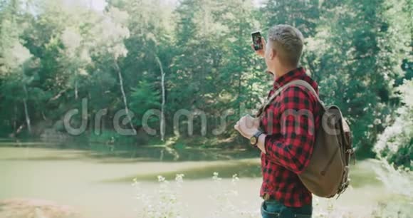 英俊的男人在绿色自然上的肖像视频的预览图