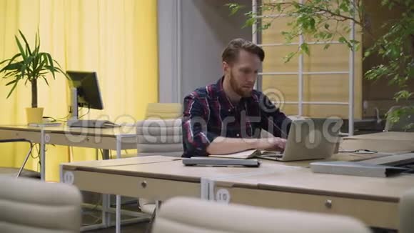 有胡子的商人在电脑上工作喝咖啡视频的预览图