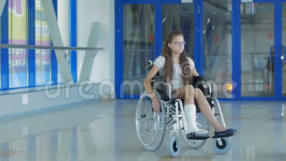 一个坐轮椅的年轻女孩站在医院的走廊里视频的预览图