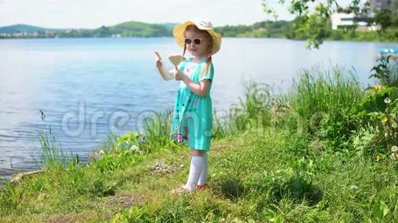 小可爱的女孩在海边吃着心形的冰淇淋视频的预览图