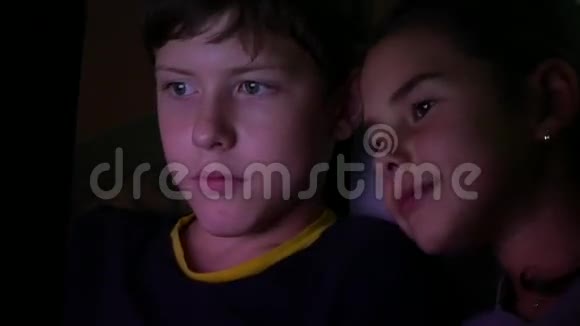 男孩和女孩晚上在电脑上玩电脑游戏视频的预览图