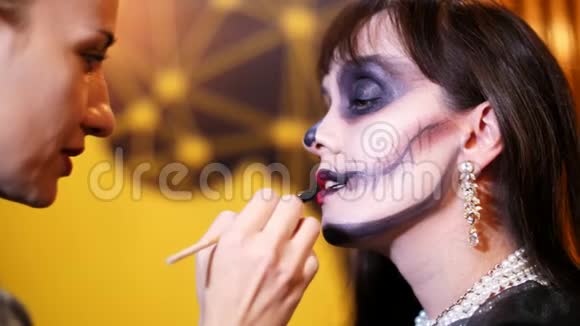 万圣节派对化妆师在万圣节派对上给一个黑发女人的脸上画了一个可怕的妆容在视频的预览图