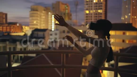 使用虚拟现实耳机在屋顶使用虚拟现实耳机晚上有虚拟现实体验视频的预览图