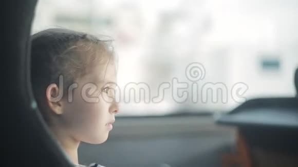 一个小女孩坐在窗边的公共汽车上视频的预览图