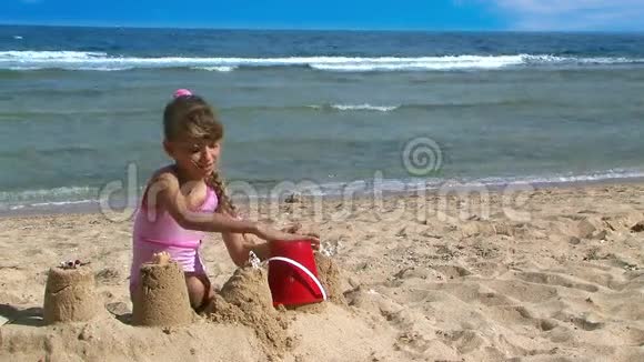 在海滩上做沙堡的女孩视频的预览图