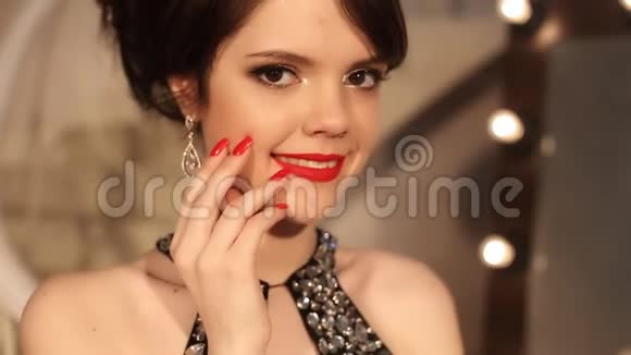 幸福微笑的女孩化妆和发型红色指甲和耳环首饰年轻漂亮的黑发女郎视频的预览图