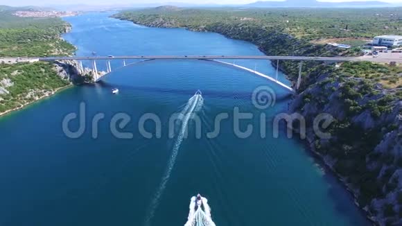 克罗地亚达尔马提亚运河上快艇驶近大桥的鸟瞰图视频的预览图