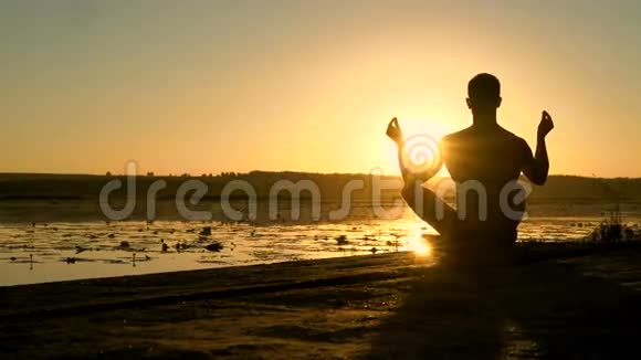 日落时分人们在海滩上练习冥想的剪影4K视频的预览图
