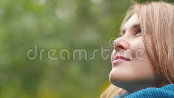 一个年轻的女人呼吸着干净的空气微笑着看着天空愉快地闭上眼睛视频的预览图