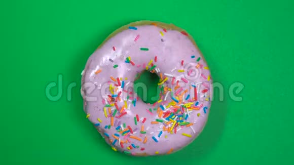 美味新鲜的甜甜圈特写镜头旋转在绿色背景上视频的预览图